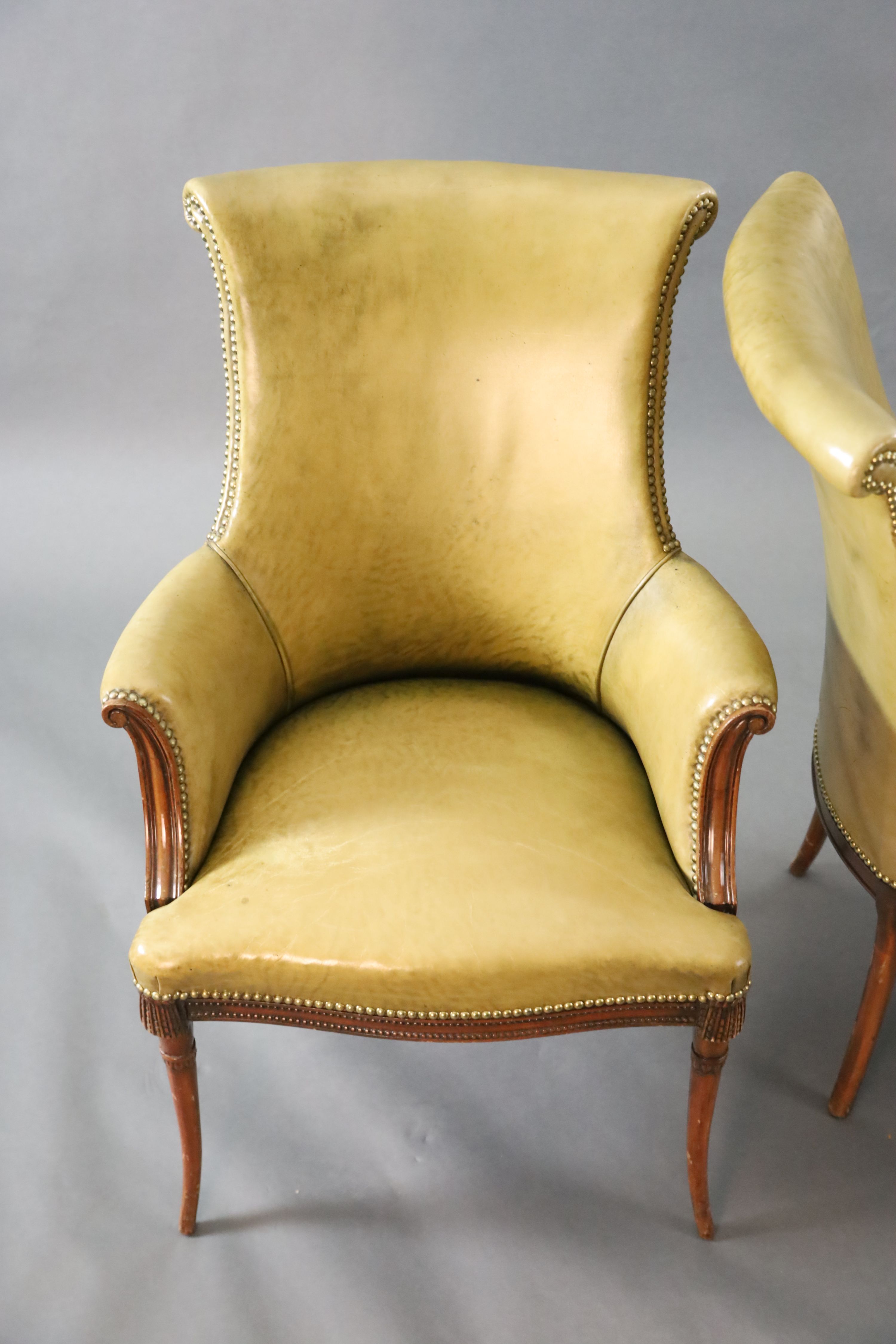A pair of Regency style leather and mahogany library chairs, W.2ft 3in. D.2ft 3in. H.3ft 2in.